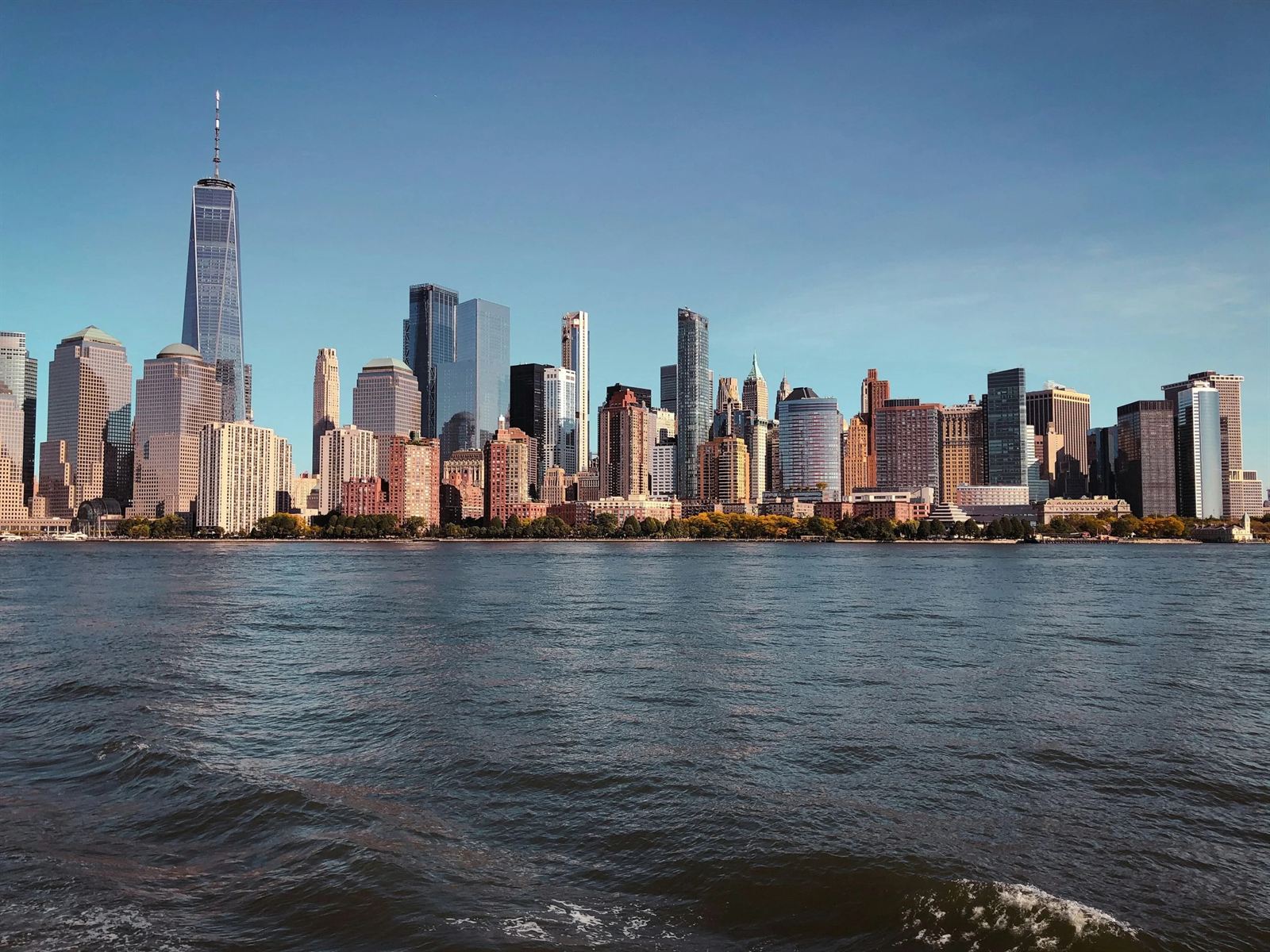 Lower Manhattan skyline seen from the harbor in late-afternoon light